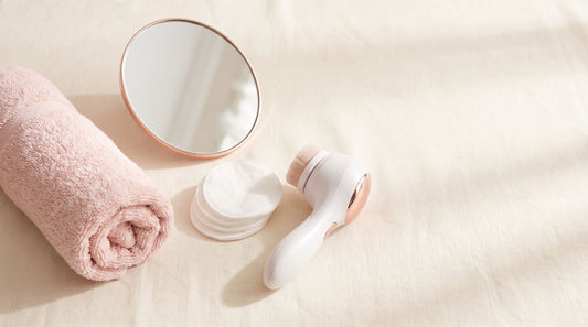 Flat lay rosado con toalla, espejo y dispositivo de depilación